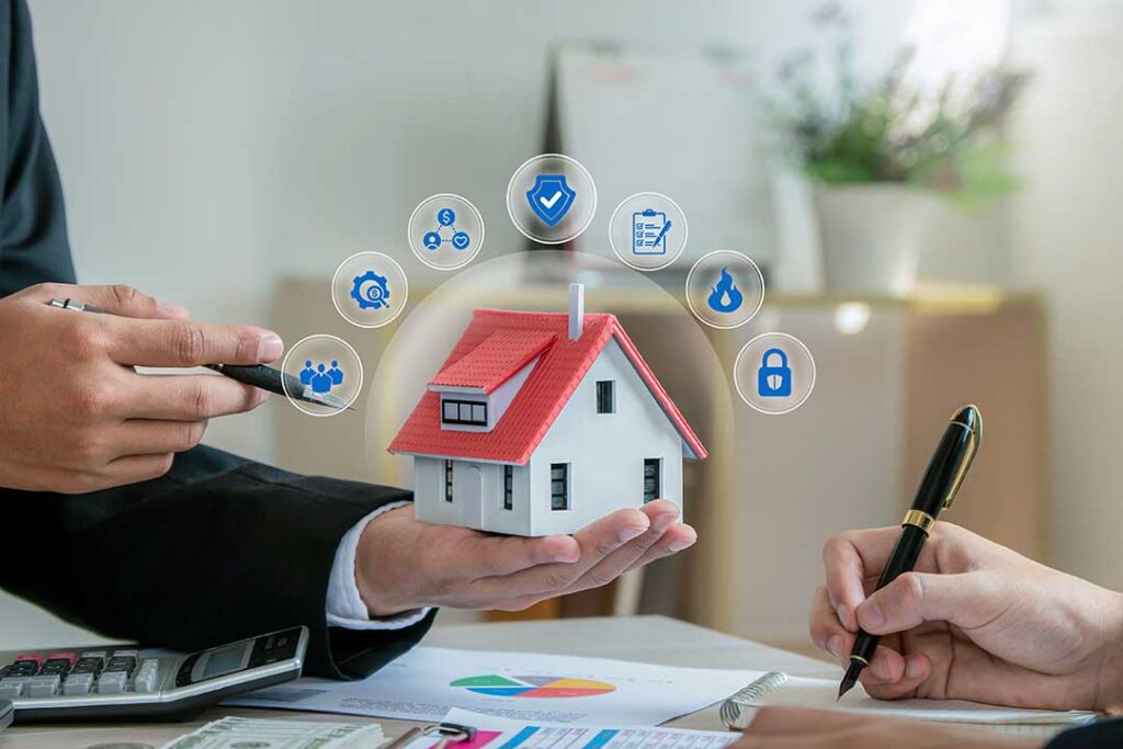 A family reviews insurance documents together at their kitchen table, looking over papers and a laptop.